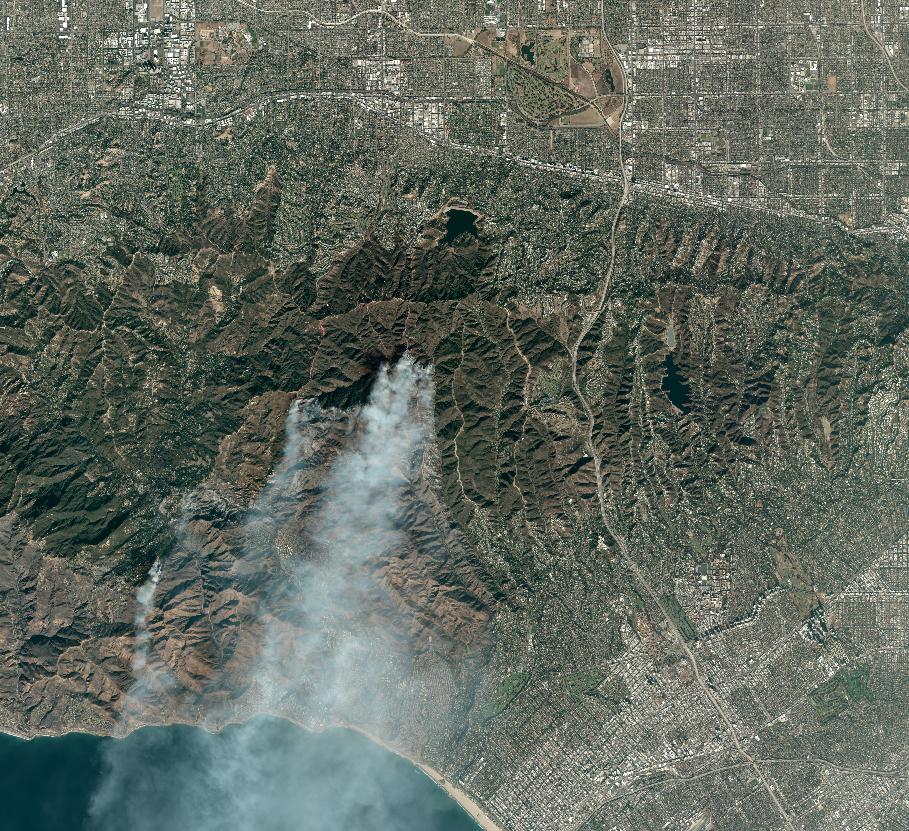 Satellite image of the LA area on January 10, 2025. Smoke plumes are visible rising from the still-burning green areas.