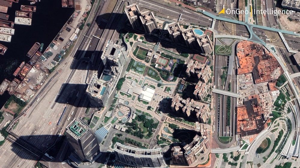 High-resolution satellite image of a city center with visible buildings and streets, illustrating an article about satellite imagery pricing.