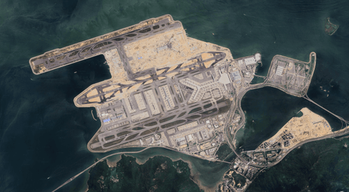 Satellite image showing a peninsula or island with extensive infrastructure, surrounded by water